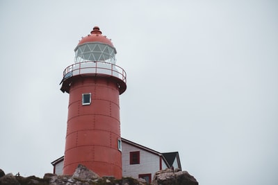 Red and white cement under the gray sky the lighthouse
